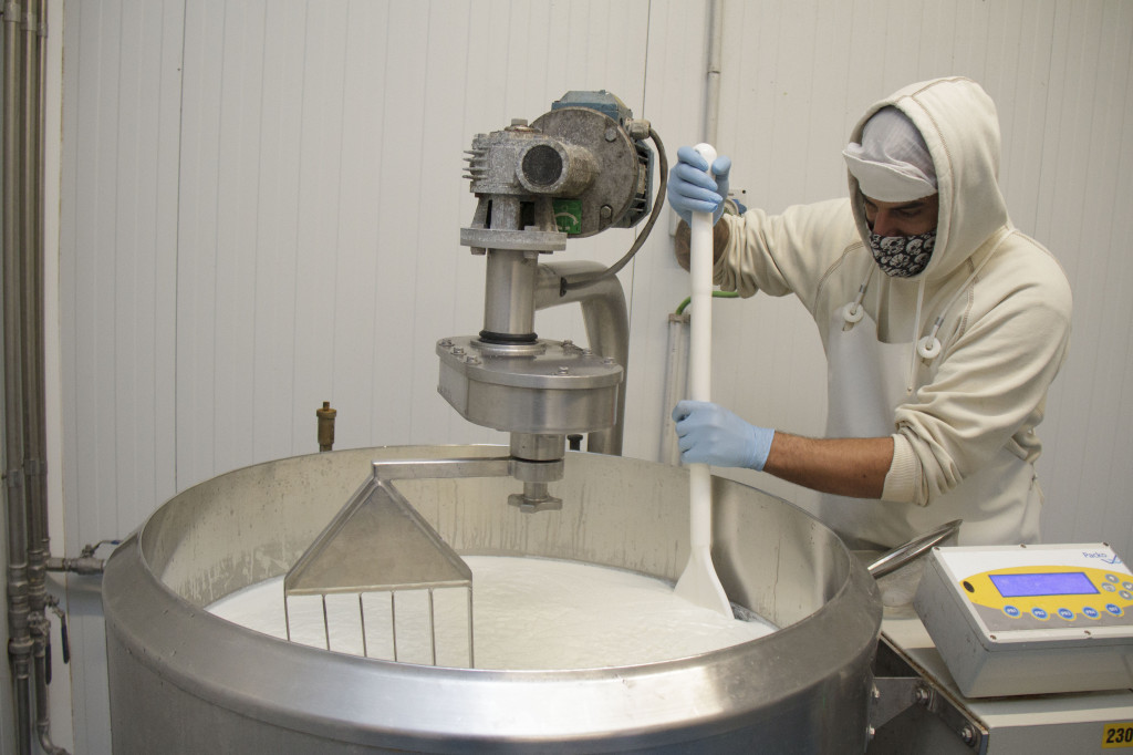 Una persona mezclando leche de cabra en una máquina