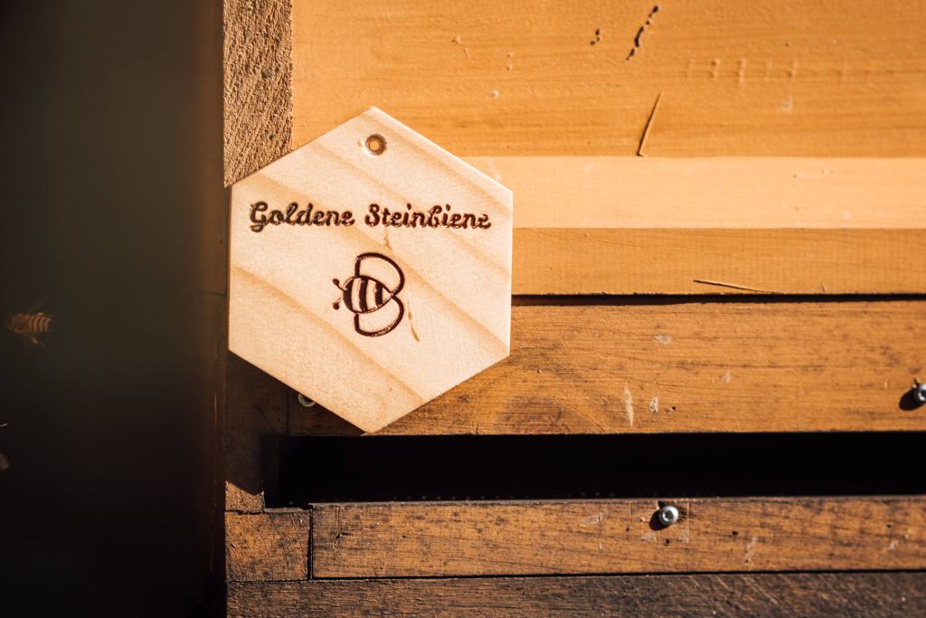 A wooden plaque on a bee colony