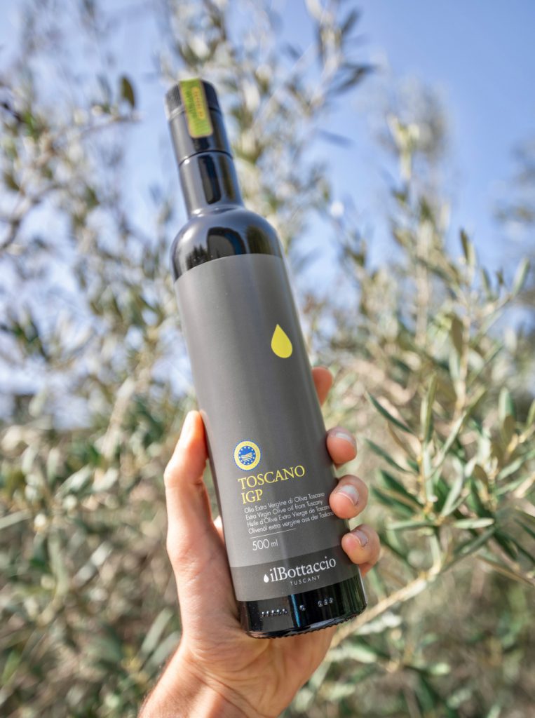 Une main qui tient une bouteille d'huile d'olive extra vierge Il Bottacio 